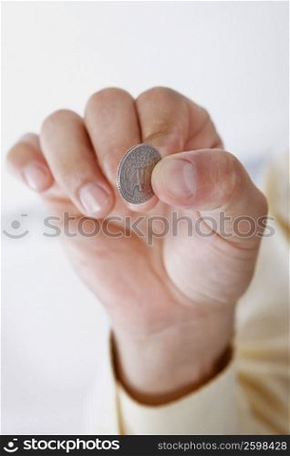 Close-up of a person&acute;s hand holding a coin