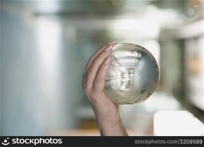 Close-up of a person&acute;s hand holding a crystal ball