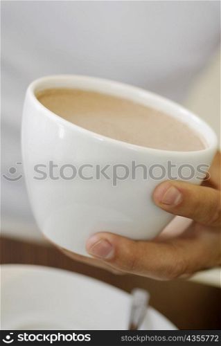 Close-up of a person&acute;s hand holding a cup of coffee