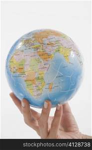 Close-up of a person&acute;s hand holding a globe