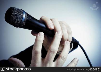 Close-up of a person&acute;s hand holding a microphone