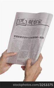 Close-up of a person&acute;s hand holding a newspaper