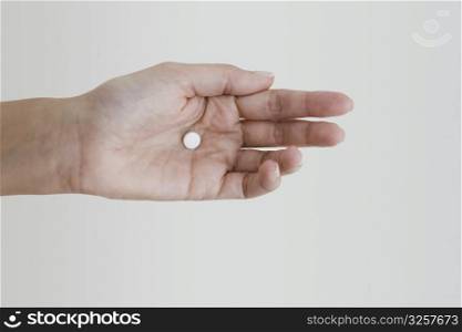 Close-up of a person&acute;s hand holding a pill