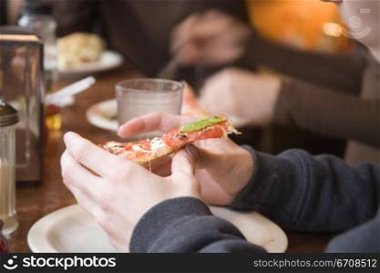 Close-up of a person&acute;s hand holding a pizza