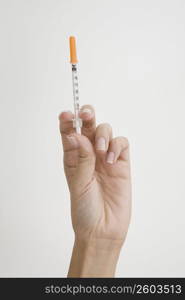 Close-up of a person&acute;s hand holding a syringe