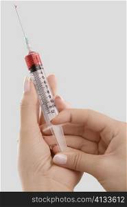 Close-up of a person&acute;s hand holding a syringe