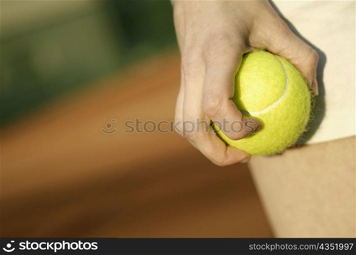 Close-up of a person&acute;s hand holding a tennis ball