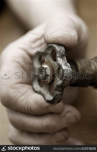 Close-up of a person&acute;s hand holding a valve