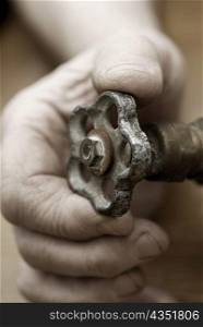 Close-up of a person&acute;s hand holding a valve