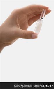 Close-up of a person&acute;s hand holding a vial