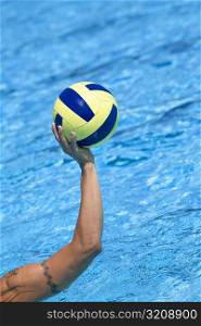 Close-up of a person&acute;s hand holding a water polo ball in a swimming pool