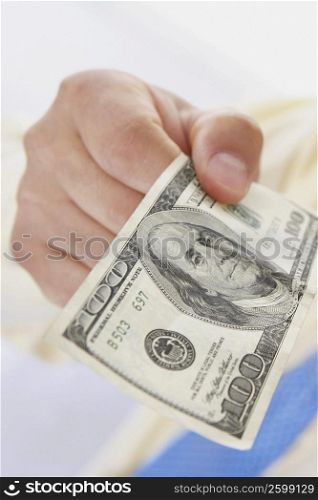 Close-up of a person&acute;s hand holding an American one hundred dollar bill