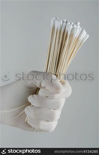 Close-up of a person&acute;s hand holding cotton swabs