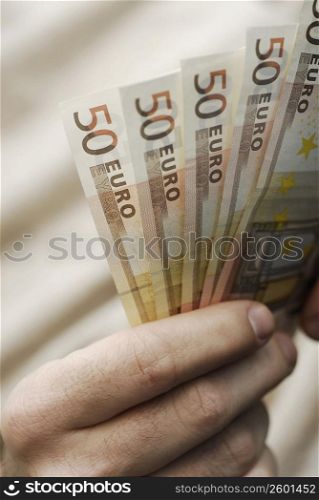 Close-up of a person&acute;s hand holding fifty Euro banknotes
