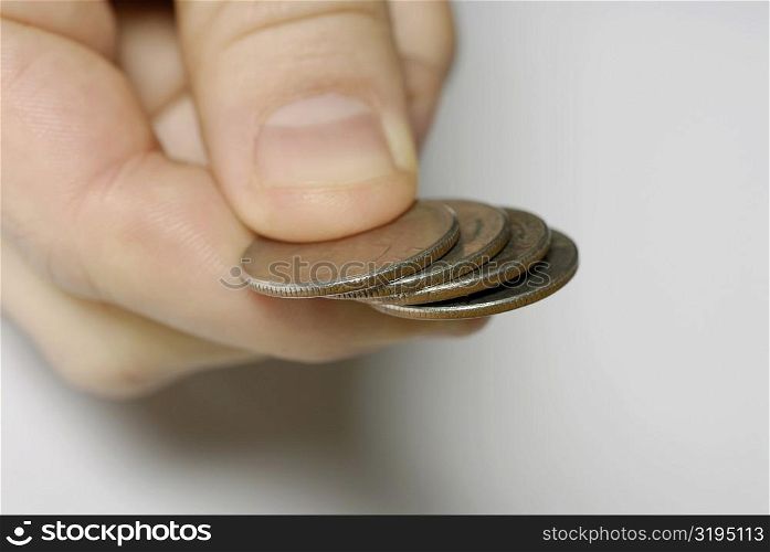 Close-up of a person&acute;s hand holding four coins