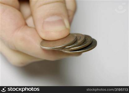 Close-up of a person&acute;s hand holding four coins