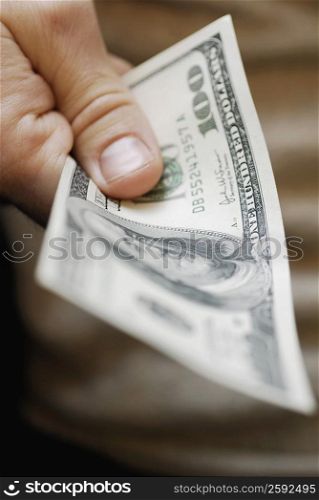 Close-up of a person&acute;s hand holding one hundred dollar bill