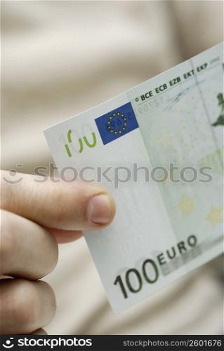 Close-up of a person&acute;s hand holding one hundred Euro banknote