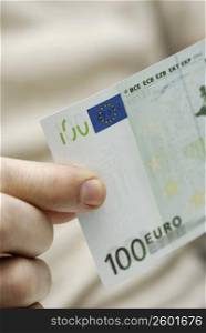 Close-up of a person&acute;s hand holding one hundred Euro banknote