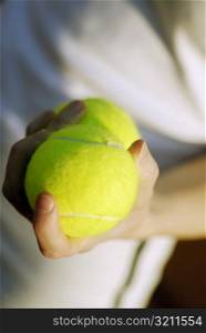Close-up of a person&acute;s hand holding two tennis balls