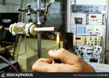 Close-up of a person&acute;s hand lighting a cigarette on a testing machine in a manufacturing plant, Richmond, Virginia, USA