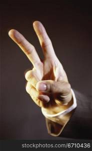 Close-up of a person&acute;s hand making the victory sign