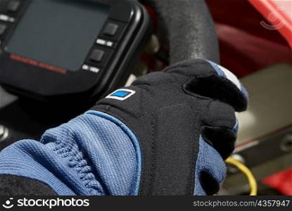 Close-up of a person&acute;s hand on the steering wheel of a go-cart
