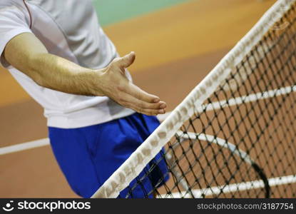 Close-up of a person&acute;s hand over a tennis net