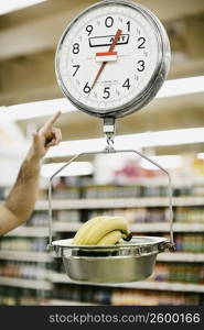 Close-up of a person&acute;s hand pointing towards a weighing scale