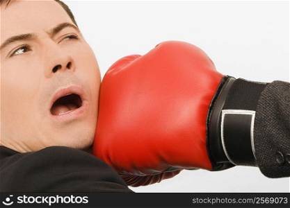 Close-up of a person&acute;s hand punching a businessman