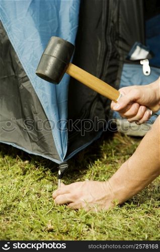 Close-up of a person&acute;s hand putting up a tent