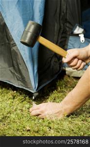 Close-up of a person&acute;s hand putting up a tent
