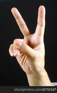 Close-up of a person&acute;s hand showing the victory sign