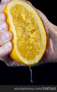 Close-up of a person&acute;s hand squeezing a tangerine