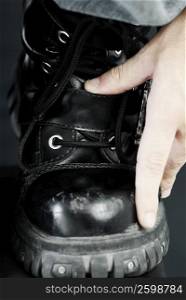 Close-up of a person&acute;s hand touching a boot