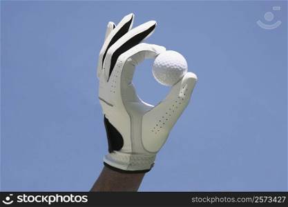 Close-up of a person&acute;s hand wearing a glove and holding a golf ball