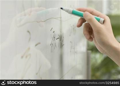Close-up of a person&acute;s hand writing on a whiteboard