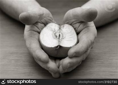 Close-up of a person&acute;s hands holding a cross section of an apple