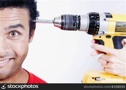 Close-up of a person&acute;s hands holding a drill machine at a young man&acute;s head