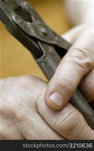 Close-up of a person&acute;s hands holding a pair of pliers