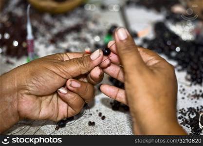 Close-up of a person&acute;s hands making beaded jewelry, Izamal, Yucatan, Mexico