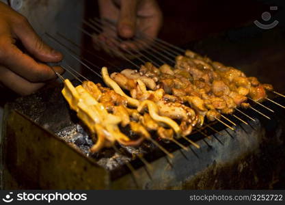 Close-up of a person&acute;s hands roasting seafood, Nanjing, Jiangsu Province, China