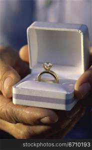 Close-up of a person holding a box with a ring