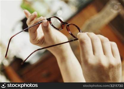 Close-up of a person holding eyeglasses