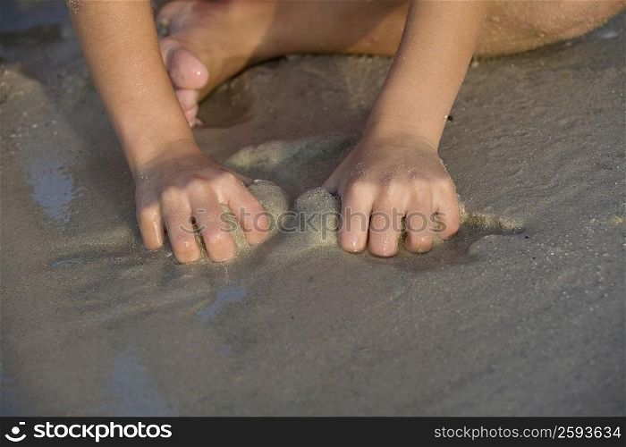 Close-up of a person playing with sand on the beach