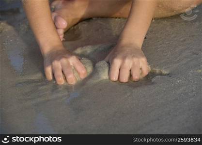 Close-up of a person playing with sand on the beach