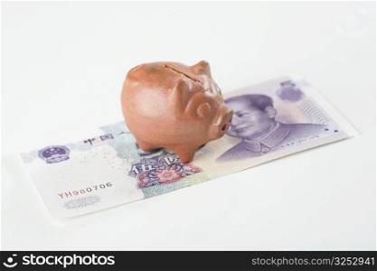 Close-up of a piggy bank on Chinese currency