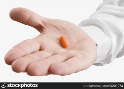 Close-up of a pill on a male doctor&acute;s palm