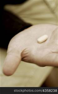 Close-up of a pill on a person&acute;s hand