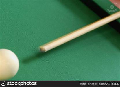Close-up of a pool cue hitting a pool ball
